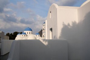 A white building with blue domes, likely part of a historical or cultural site. - Aegean Studios Perissa (Santorini)