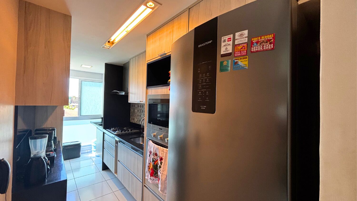 A modern kitchen with stainless steel appliances, wooden cabinets, and a built-in oven.