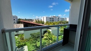 Varanda com vista para uma área residencial, com edifícios e vegetação.