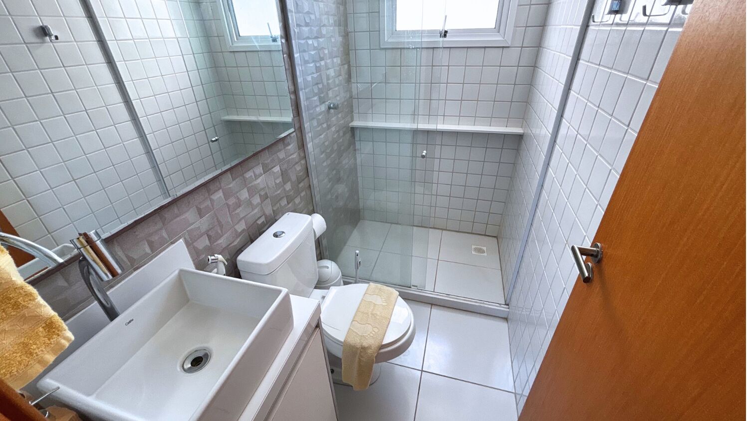 A small bathroom with a toilet, sink, and shower.