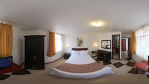 A hotel room with a large bed, a wardrobe, a desk, and a mirror. - Hotel Makroz Colonial (Latacunga)
