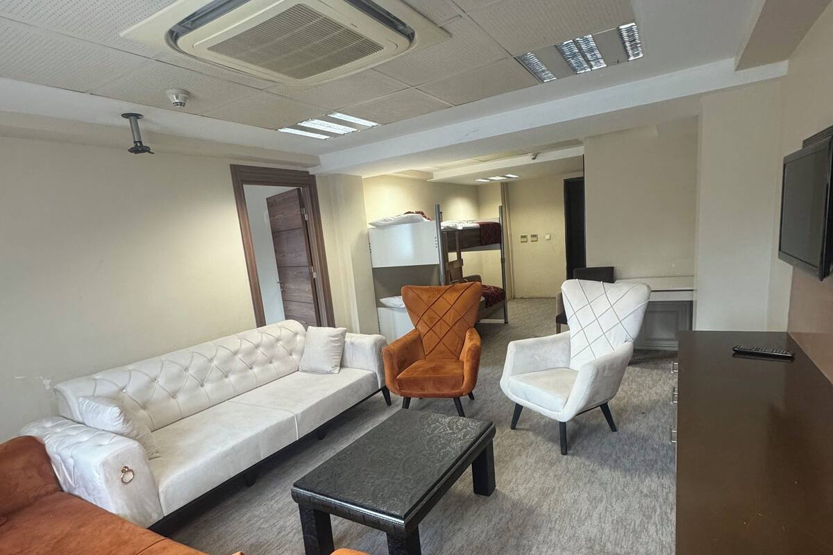 A living room with a sofa, armchairs, a coffee table, and a TV.