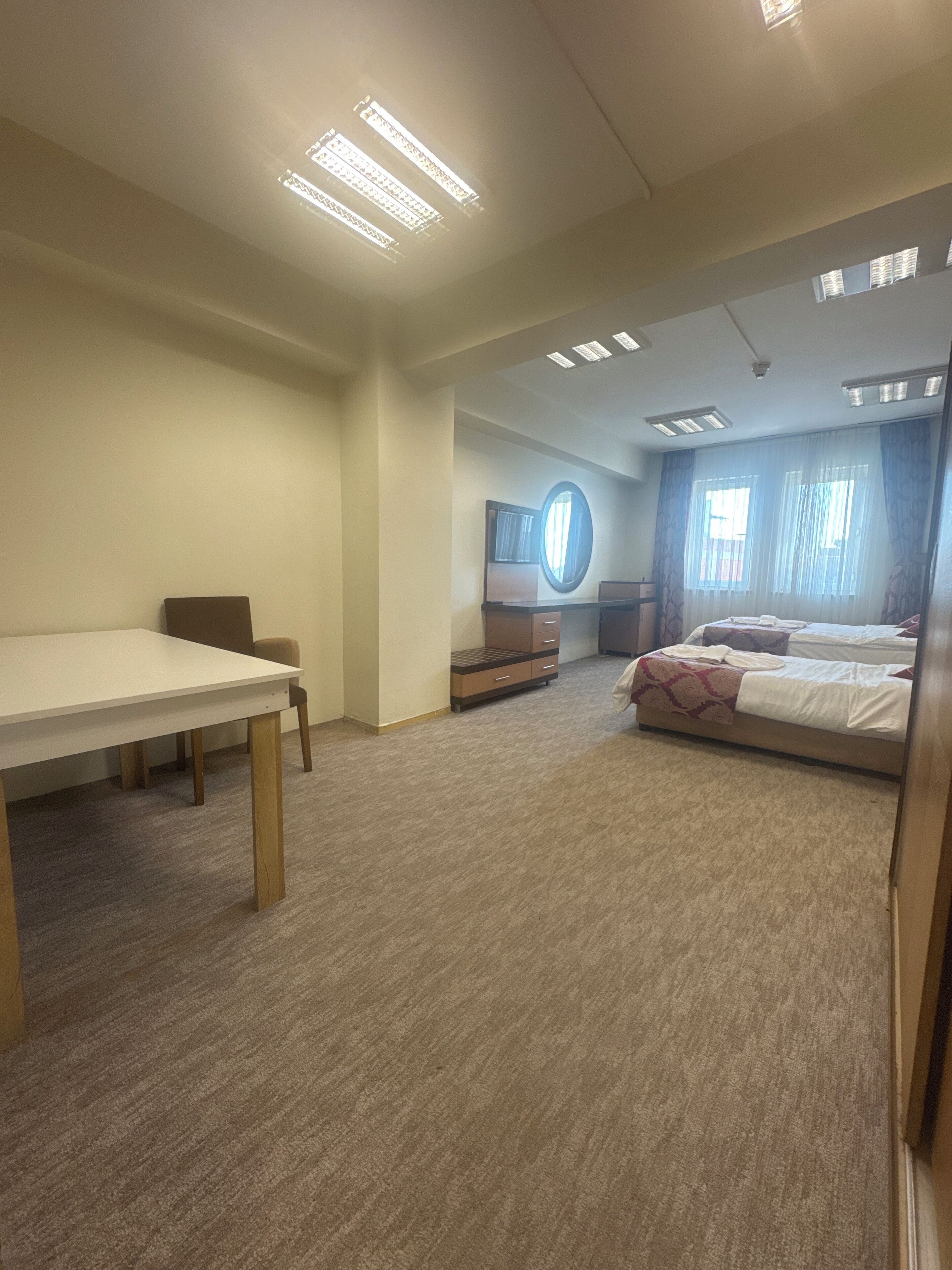 Une chambre d’hôtel avec un lit, un bureau et une télévision.