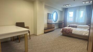 Une chambre d’hôtel avec un lit, un bureau et une télévision.