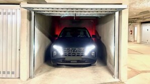 A car in a garage with a red interior wall and a white door. - Le Janus - at the foot of the slopes, terrace with sauna, garage (Montgenèvre)
