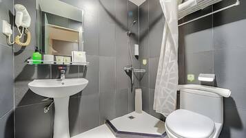 Een badkamer met een wastafel op voet, toilet, douche en een spiegel.