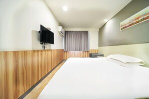 A hotel room with a large bed, a flat-screen TV mounted on the wall, a window with curtains, and a painting on the wall. - Youhai Hotel (Shanghai University Qinghe Road) (Shanghai)