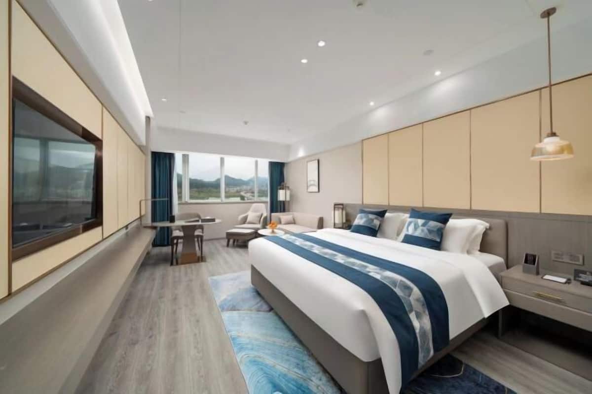 Une chambre d’hôtel moderne avec un grand lit, un bureau et une vue sur les montagnes.