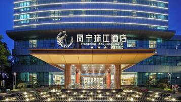 A modern hotel building with a prominent entrance and a well-lit facade.