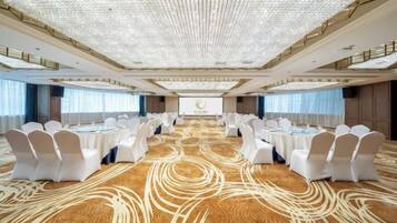 A large conference room with a long table, white chairs, and a carpeted floor.