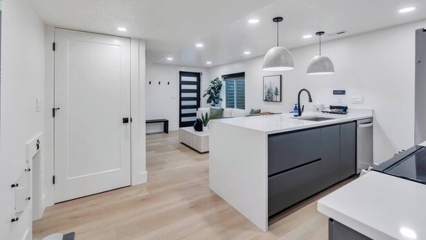 Una cocina moderna con una isla central, iluminación empotrada y una zona de comedor con banco.