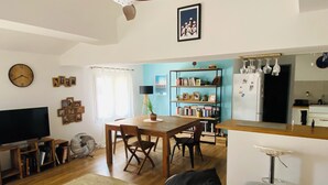 A living room with a TV, wooden furniture, a dining table, and a bookshelf. - Very atypical downtown apartment. Old oil mill! (La Crau)
