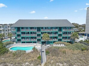 A multi-story hotel with balconies, a swimming pool, and a parking area. - Oceanfront 2 BR Villa-Pool-Corner Balcony-King Bd (North Myrtle Beach)