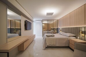 A modern bedroom with a large bed, a bedside table, a built-in bench, and a large mirror. - Cf04 Praia do Forte Cobertura frente mar (Cabo Frio)