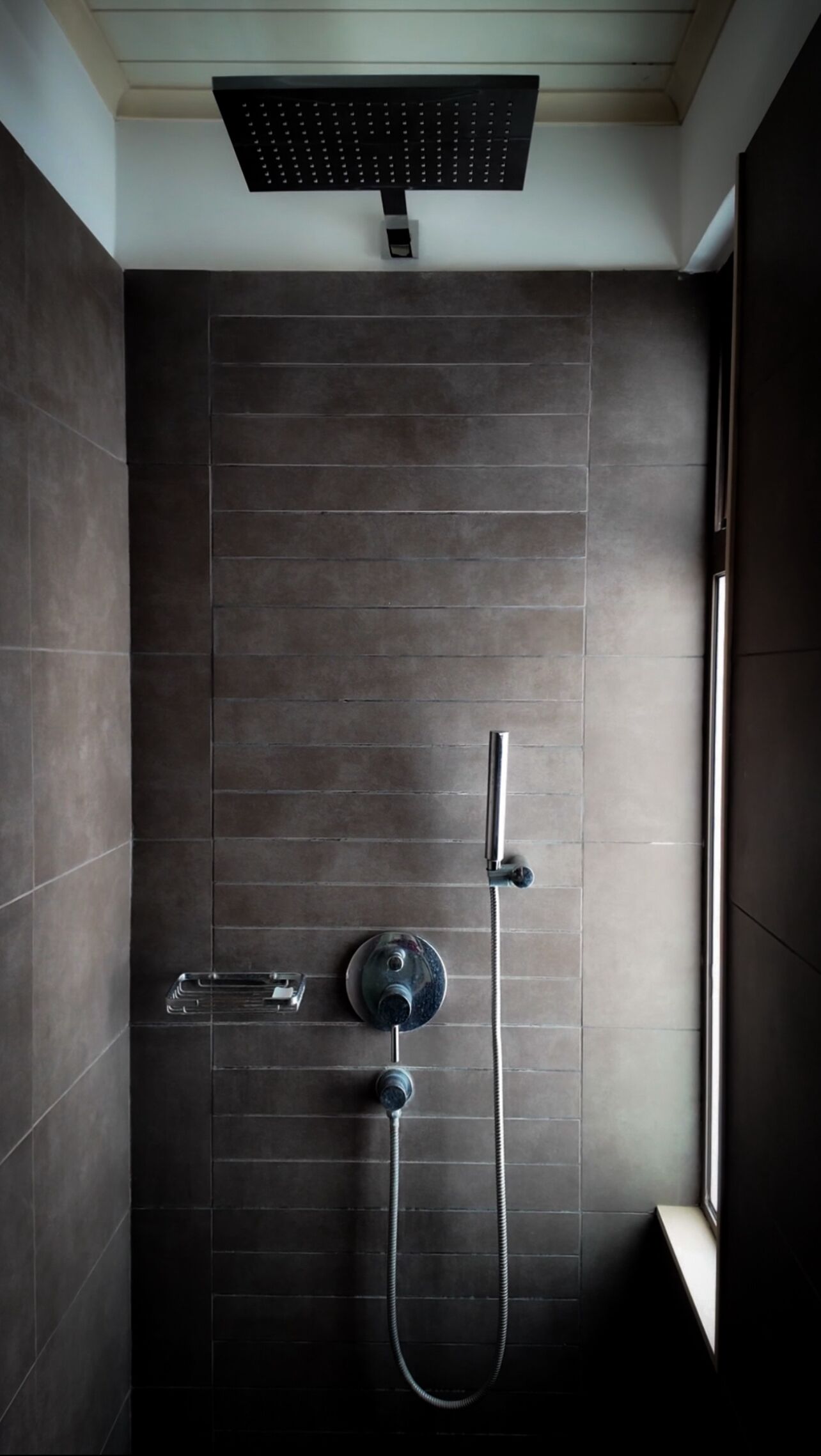 Eine moderne Dusche mit Handbrause und Deckenbrause.