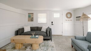 A living room with a grey sofa, a wooden coffee table, and a blue armchair.