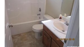 A small bathroom with a toilet, a sink, and a bathtub. - Spacious 5-bedroom house with WiFi, fitness room in wonderful Hooper (Hooper)