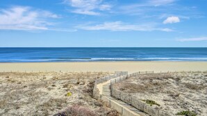 A sandy beach with a wooden boardwalk leading to the ocean. - Sea Gate 307 by Seaside Vacations & Sales (Ocean City)