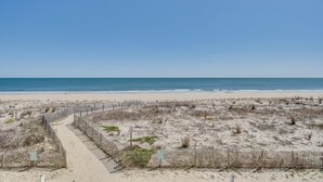 A sandy beach with a wooden fence and a clear blue sky. - Sea Gate 205 by Seaside Vacations & Sales (Ocean City)