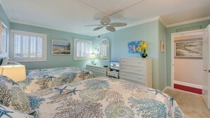 A bedroom with a bed, a dresser, a ceiling fan, and a door. - Sea Gate 205 by Seaside Vacations & Sales (Ocean City)