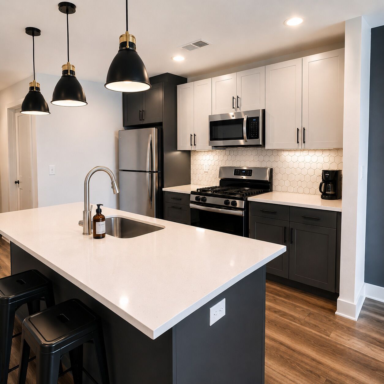 A modern kitchen with a central island, stainless steel appliances, and pendant lighting.