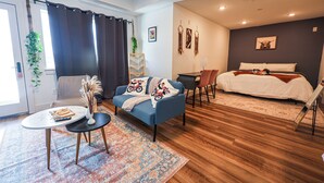 A modern hotel room with a bed, a sofa, a desk, and a small table. - Studio Apartment - in*the*Philadelphia. (Philadelphia)