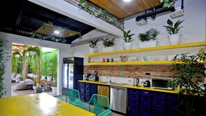 A modern kitchen with a yellow countertop, blue storage bins, and a brick backsplash.