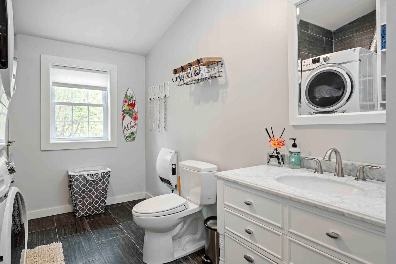 A modern bathroom with a toilet, sink, and built-in washing machine.
