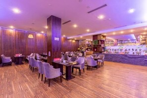 A restaurant with wooden flooring, multiple tables and chairs, and a counter area. - Xiangtan JYMGM Grand International Hotel (Xiangtan)