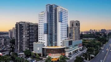 Un hotel moderno de gran altura, con diseño vanguardista, fachada de vidrio destacada y entrada central.