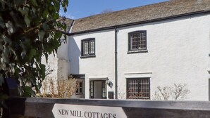 A white building with a sign reading "NEW MILL COTTAGES." - 2 New Mill Cottages (Newton Abbot)