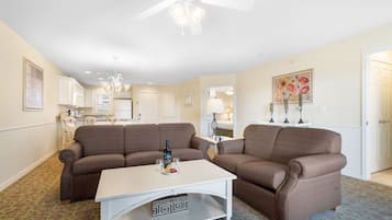 A living room with two brown sofas, a white coffee table, and a ceiling fan.