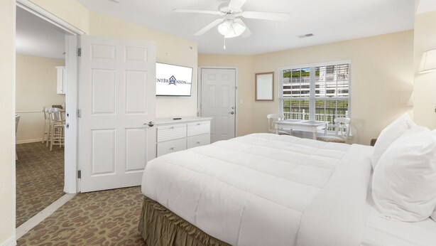A bedroom with a bed, a ceiling fan, a desk, and a window with blinds. - Table Rock Lake-Access Kim City Condo w/ Community Pool, Mini Golf & Free Daily Tickets (Kimberling City)