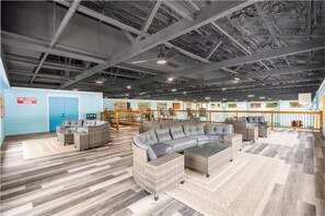 A spacious indoor area with a large sectional sofa, wicker furniture, and a fire control room sign.