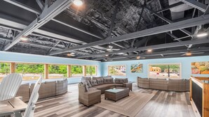 A spacious living area with a sectional sofa, a coffee table, and a dining table.