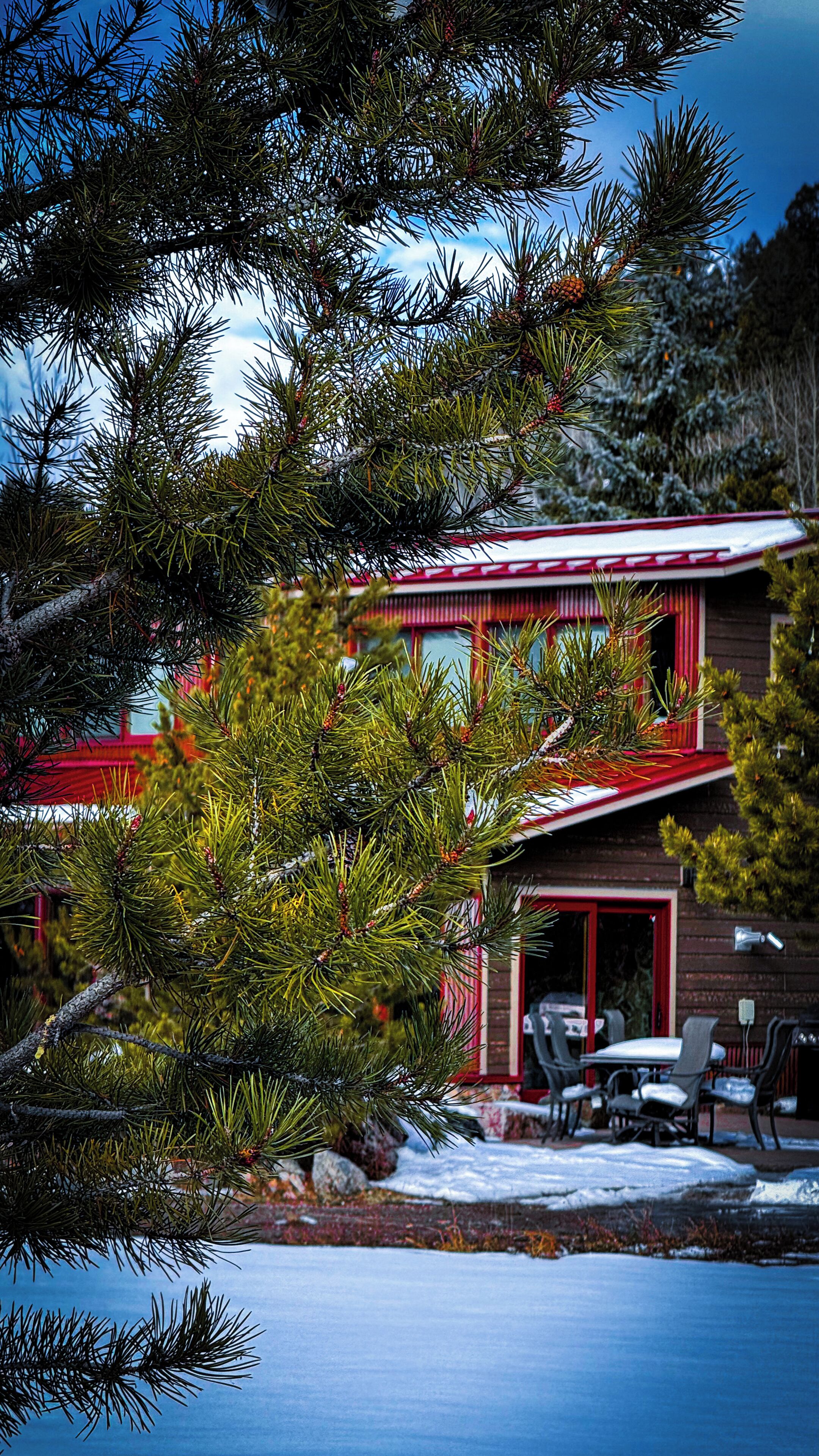A two-story building with a red roof and a covered patio area.