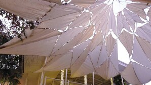 Uma área de piscina interna com um espaço de estar coberto e espreguiçadeiras à beira da piscina.