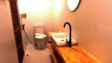 Une petite salle de bain avec des toilettes, un lavabo et un miroir.