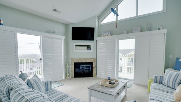 A living room with a fireplace, a television, and a large window.
