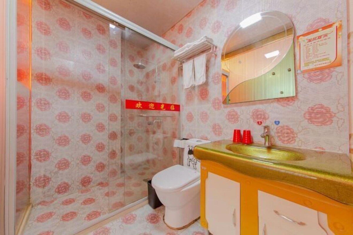 A bathroom with a shower, toilet, and sink.