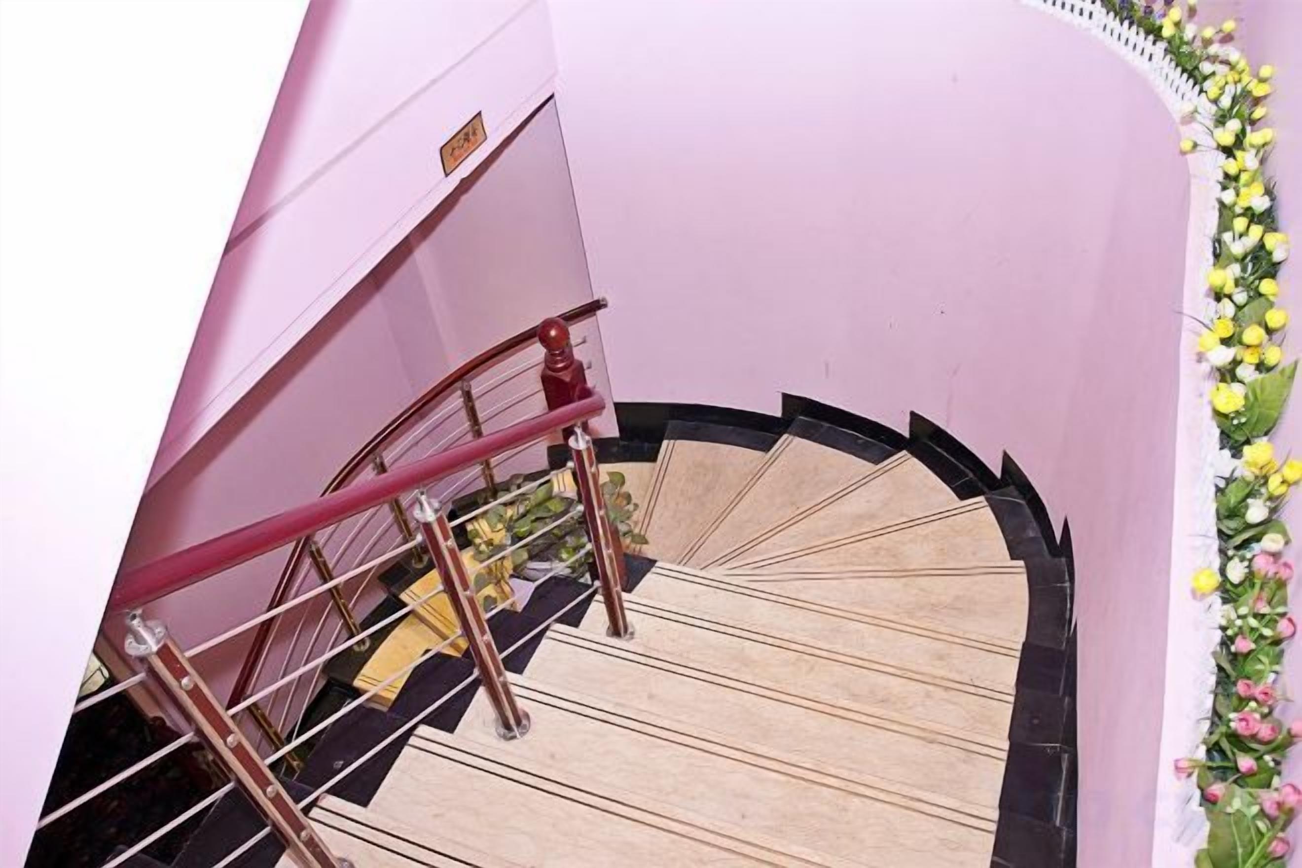 A spiral staircase with a handrail and a wall-mounted sign.