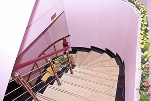 A spiral staircase with a handrail and a wall-mounted sign. - Shang Yi Hotel (Shanghai)