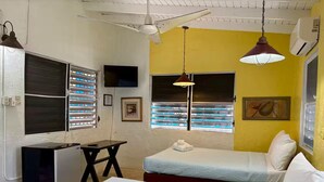 Una habitación con dos camas, un escritorio y una ventana con persianas.