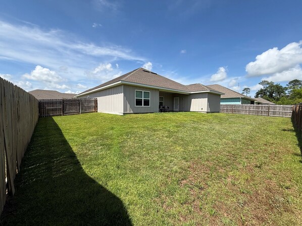 A residential house with a fenced backyard, a covered porch, and a clear sky. - 4 BR/3BA (2K, Q, 2T) New Construction.  Pet friendly (Foley)