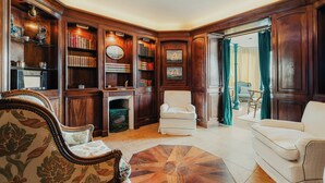 Una biblioteca tradicional con estanterías de madera, chimenea y muebles clásicos.