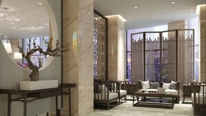 A modern lobby with a marble reception desk, a seating area with sofas and a coffee table, and a decorative tree sculpture. - Haiyi Fino Hotel (Yichang Wanda Plaza Three Gorges Vocational College Store) (Yichang)