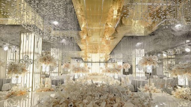 A luxurious venue with a central floral arrangement, elegant seating, and reflective ceiling elements. - Haiyi Fino Hotel (Yichang Wanda Plaza Three Gorges Vocational College Store) (Yichang)