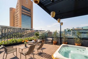 A rooftop terrace with a hot tub, seating area, potted plants, and a city view. - Collections by ULIV Palacio (Mexico City)