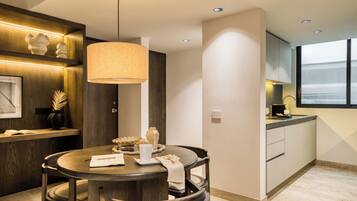 Una cocina moderna con una mesa redonda, sillas de madera y una lámpara colgante.