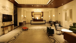 Un'ampia hall con reception, un lampadario e moderne zone salotto.